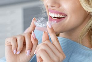 female patient holding invisible braces